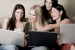 Four girlfriends with three laptop computers